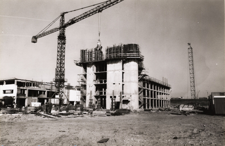 Het GCEI in aanbouw in 1976. Midden: het kantoorgebouw, links het datacenter. Op de achtergrond de spoorlijn en de wijk Holendrecht in aanbouw.  